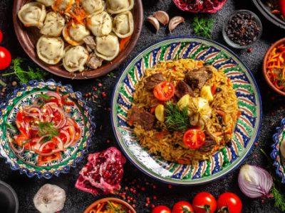 Traditional Uzbek oriental cuisine. Uzbek family table from different dishes in national dishes for the New Year holiday. The background image is a top view, copy space, flat lay